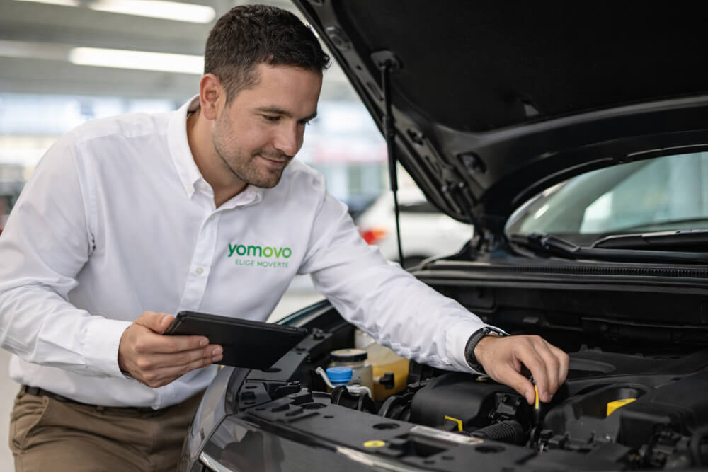 Mecánico yomovo revisando un coche